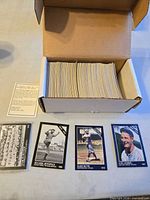 Open box showing stacked cards, three colorized cards, checklist insert visible