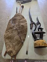 Overall view of shield, spear, club and antelope sculpture with ruler