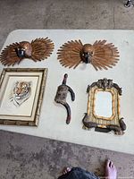 Lot overview showing two carved bird plaques, tiger print, mirror, partial doll