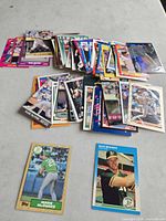 Scattered stack of Mark McGwire baseball cards with two rookie cards displayed
