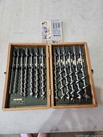 Open wooden case displaying two rows of Irwin auger bits and instruction pamphlet