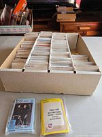 Long card box filled with sorted hockey cards and two sealed sets in front