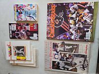 Lot overview showing three sealed Toys "R" Us Master Photo sets, two card magazines and two sports programs