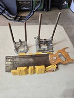 Miter box, back saw and two drill press attachments on table