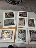Group of eight matted foil prints on table