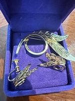 brooch and earrings inside purple-lined box