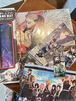 Overall lot showing playmat box, prints, lanyard, keychains