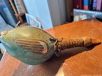 Full side view of green leather body, braided neck and stopper