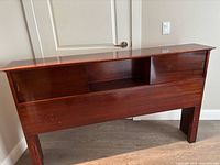 Front view of cherry headboard showing storage openings and overall finish