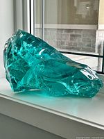 Full view of blue-green slag glass piece on windowsill