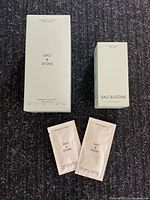 Front view of boxed body wash, boxed body mist, two sample packets