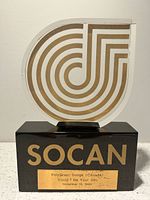 Front view showing SOCAN logo plaque on black base with engraved plate
