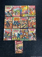 Group shot of 13 western comic books laid out on dark carpet