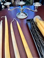 Overview of candelabra, loose beeswax tapers, snuffer tools in tray