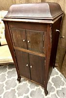 Front view showing cabinet, domed top, crank handle, doors closed