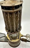 Full view showing brass carbide lamp with ventilated chimney and glass chamber