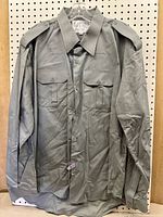 Front view of grey uniform shirt on hanger showing overall condition