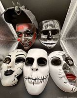 Group shot of five masks and rubber bat