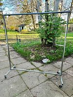 Full view of chrome garment rack standing on patio