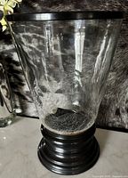 Full view of clear crackle glass vase on black pedestal base