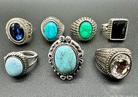 Group shot of all seven silver-tone costume rings