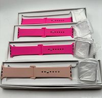 Four boxed silicone watch bands, three bright pink one nude-pink