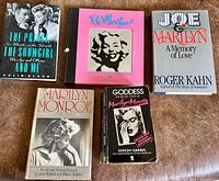 Front covers of all five Marilyn Monroe books displayed on surface