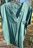 Front view of sage green MOBB scrub top