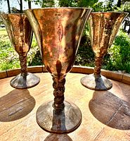 Three brass goblets standing upright showing patina and design