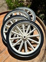 Four white-spoke wheels stacked showing overall appearance