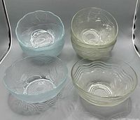 Eight pressed glass bowls showing both patterns
