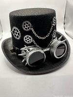 Three-quarter view of hat showing gears, chain, goggles