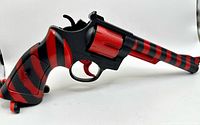 full left side view of red and black striped plastic toy revolver