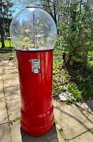 Full view of red Beaver floor gumball machine outdoors