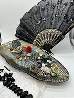 Group of items: compact, tray with buttons and jewelry bits, black fan, broken bead bracelet