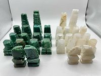 Full set of green and white stone chess pieces arranged