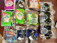 Overview of all 12 sealed Happy Meal toys laid out on table