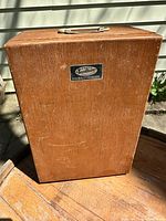 Front view of Tasco Deluxe wooden case with brand label