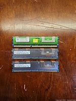 Three DDR3 RDIMM sticks laid out on table