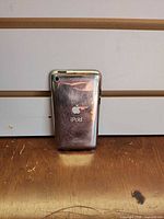 Rear chrome view showing Apple logo, rear camera, overall scratches