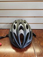 Front top view of black helmet showing vents and mesh accents