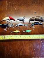 Group shot of eight lures with measuring tape for scale