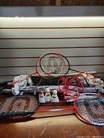Complete badminton set with net, rackets, shuttlecocks, poles visible