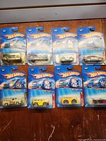 All eight sealed 2004 Hot Wheels cars laid out—three Pin Hedz, three Blings, two Track Aces