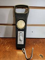 Front view of fish scale showing dial, label and hook