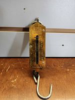 Front view showing brass faceplate, capacity scale, maker marks, hook