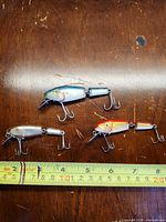 All three lures side by side with measuring tape for scale