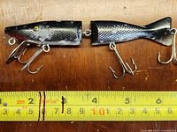 Full side view of the jointed lure with measuring tape showing length