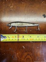 Side view of South Bend Rascal lure beside ruler showing length