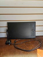 Front view of XP-Pen Star 06 tablet with stylus on stand and USB cable